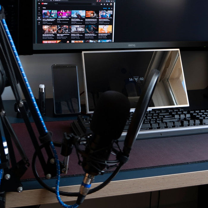 Real gaming desk with a standalone microphone boom arm keyboard monitor and PC